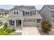 Two-story home with a covered front porch, two-car garage, neutral paint, and neatly kept front yard at 12940 Brier Ct, Firestone, CO 80504