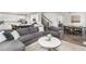 Open-concept living area with gray sectional sofa, kitchen, and dining space at 12940 Brier Ct, Firestone, CO 80504