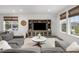 Well-lit living room featuring a gray sectional sofa, entertainment center, and natural light at 12940 Brier Ct, Firestone, CO 80504