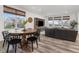 Open-concept living and dining area with hardwood floors, large windows, and stylish furniture at 12940 Brier Ct, Firestone, CO 80504