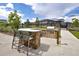 Outdoor kitchen with stone bar, grill, and seating area, perfect for entertaining guests in the community at 12940 Brier Ct, Firestone, CO 80504