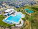 Aerial view of resort-style pool with lap lanes and splash pad, surrounded by lush landscaping and community homes at 12940 Brier Ct, Firestone, CO 80504