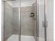 Modern shower with gray tile, a built-in shelf and a glass door at 12940 Brier Ct, Firestone, CO 80504