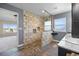 Modern bathroom featuring a stone shower with pebble floor and wood-look tile flooring at 20670 Bridlewood Ln, Parker, CO 80138