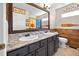 Bathroom with double sinks, wood-look tile, and lake-themed decorations at 20670 Bridlewood Ln, Parker, CO 80138
