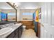 Bathroom with double sinks, tub/shower with curtain, and lake-themed decorations at 20670 Bridlewood Ln, Parker, CO 80138