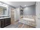 Bathroom featuring a soaking tub with stone surround, dark vanity, and wood-look tile flooring at 20670 Bridlewood Ln, Parker, CO 80138