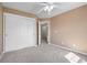 Cozy bedroom features plush carpeting, a ceiling fan, and a closet with paneled sliding doors at 20670 Bridlewood Ln, Parker, CO 80138