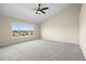 Spacious bedroom with neutral carpet, vaulted ceiling, a ceiling fan, and a large window at 20670 Bridlewood Ln, Parker, CO 80138