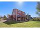 Backyard view of the home and deck features a green lawn and mature trees at 20670 Bridlewood Ln, Parker, CO 80138