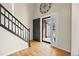 Bright foyer with hardwood floors, staircase with black railing, and an open doorway at 20670 Bridlewood Ln, Parker, CO 80138