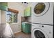 Laundry room with green cabinets, a window and a stacked washer and dryer at 20670 Bridlewood Ln, Parker, CO 80138