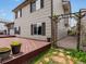 Back exterior of home with large wooden deck, black shutters, trellis and neutral siding at 5204 S Parfet Way, Littleton, CO 80127