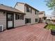 Back exterior of home with large wooden deck, black shutters and neutral-tone siding at 5204 S Parfet Way, Littleton, CO 80127
