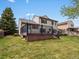 Exterior view of home and deck overlooking a grassy backyard and lush green landscaping at 5204 S Parfet Way, Littleton, CO 80127