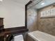 Bathroom featuring a modern tub, neutral tile, and glass block window at 5204 S Parfet Way, Littleton, CO 80127