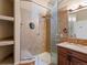 Tiled bathroom with glass enclosed shower, decorative shelves and single sink vanity at 5204 S Parfet Way, Littleton, CO 80127