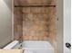 Bathroom features a tiled shower and tub combination, with built in shelves for storage at 5204 S Parfet Way, Littleton, CO 80127