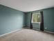 Bedroom featuring neutral carpet, light blue walls, and large window at 5204 S Parfet Way, Littleton, CO 80127