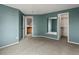 Spacious bedroom with a large mirror, carpeted floor, and view to attached bathroom and closet at 5204 S Parfet Way, Littleton, CO 80127