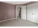 Bedroom featuring double door closet, medium gray carpet, and access to bathroom at 5204 S Parfet Way, Littleton, CO 80127