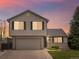 Charming two-story home featuring an attached two-car garage, manicured lawn, and brick accents at 5204 S Parfet Way, Littleton, CO 80127