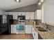 Kitchen featuring granite countertops, white cabinets, and stainless steel appliances at 5204 S Parfet Way, Littleton, CO 80127