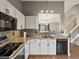 Kitchen with granite counters, white cabinets, modern appliances, and view into the living room at 5204 S Parfet Way, Littleton, CO 80127