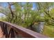 A view from a metal bridge overlooking a small creek surrounded by lush trees at 9632 W Cornell Pl, Lakewood, CO 80227