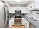 Updated kitchen with stainless steel appliances, granite countertops, and white cabinets at 9632 W Cornell Pl, Lakewood, CO 80227