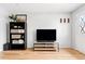 Bright living room with hardwood floors, television, and built-in storage at 9632 W Cornell Pl, Lakewood, CO 80227