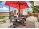 Enjoy outdoor dining on the backyard patio with a large red umbrella and seating for four at 1760 W 74Th Way, Denver, CO 80221