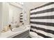 Traditional bathroom featuring a single vanity with a sink and a shower with a striped curtain at 1760 W 74Th Way, Denver, CO 80221