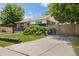 Charming brick home featuring a well-manicured lawn, driveway, and privacy fence at 1760 W 74Th Way, Denver, CO 80221