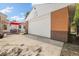 A spacious garage with a full-sized brick exterior and concrete driveway next to an outdoor seating area at 1760 W 74Th Way, Denver, CO 80221