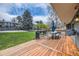 Expansive backyard featuring a wooden deck, lush green lawn, mature trees, and views of neighboring homes at 5254 W Oberlin Dr, Denver, CO 80235