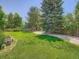 Large grassy backyard with mature trees and playground equipment, perfect for outdoor activities and entertaining at 5254 W Oberlin Dr, Denver, CO 80235