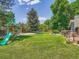 Large, lush backyard with play structure, mature trees, and deck offers space for Gathering fun and outdoor gatherings at 5254 W Oberlin Dr, Denver, CO 80235