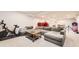 Finished basement featuring a large gray sectional, exercise equipment, and ample open space at 5254 W Oberlin Dr, Denver, CO 80235