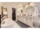 Modern bathroom with a soaking tub, double vanity, and a closet at 5254 W Oberlin Dr, Denver, CO 80235