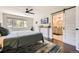 Bedroom with attached bathroom, dark wood floors, and a large window with views of the trees at 5254 W Oberlin Dr, Denver, CO 80235