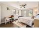 Bright bedroom featuring three windows, a ceiling fan, and a white-and-black bed frame with a colorful patterned comforter at 5254 W Oberlin Dr, Denver, CO 80235