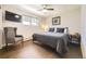 Bedroom with a chair, TV, dark wood floors, ceiling fan and a bed with a black sunflower picture on the wall at 5254 W Oberlin Dr, Denver, CO 80235