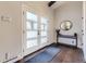 Bright foyer featuring a dark wood floor, a console table with a mirror, and a door with frosted glass panels at 5254 W Oberlin Dr, Denver, CO 80235