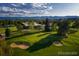 Beautiful aerial view of golf course, sand traps, and clubhouse with mountain views in the background at 5254 W Oberlin Dr, Denver, CO 80235
