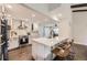 Bright kitchen with stainless steel appliances, white cabinets, island with seating and hardwood floors at 5254 W Oberlin Dr, Denver, CO 80235