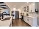 Modern kitchen with stainless steel appliances, white cabinetry, and hardwood floors at 5254 W Oberlin Dr, Denver, CO 80235