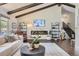 Bright living room boasts exposed beams, a modern fireplace, and expansive windows showcasing the outdoor scenery at 5254 W Oberlin Dr, Denver, CO 80235