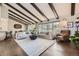 Spacious living room features exposed beams, modern sofas, and large windows overlooking the backyard at 5254 W Oberlin Dr, Denver, CO 80235