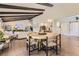 Open floor plan with exposed beams connects the living room, dining area, and kitchen, creating a spacious and inviting atmosphere at 5254 W Oberlin Dr, Denver, CO 80235